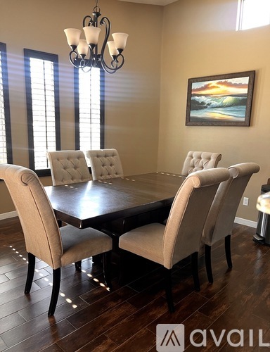 A dining room with a wooden table and chairs.