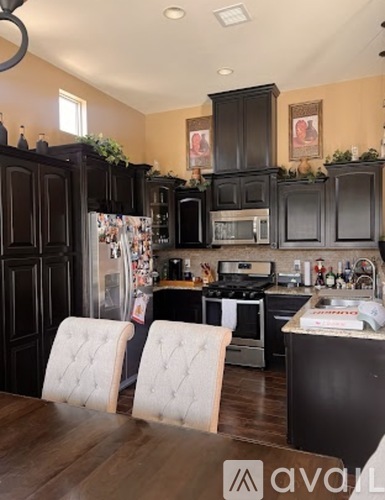 A kitchen with dark wood cabinets and a white chair.
