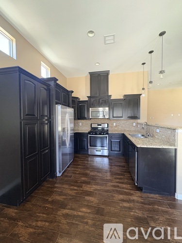 A spacious room with a ceiling fan and wooden flooring.