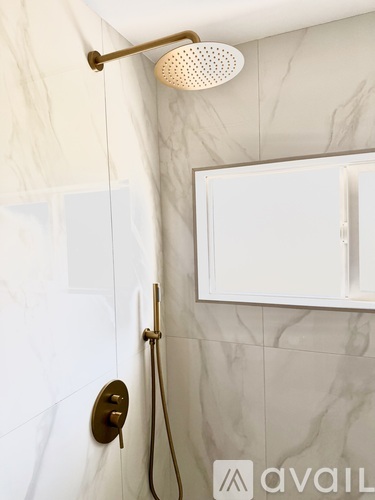 A shower head mounted on a wall with a white door.