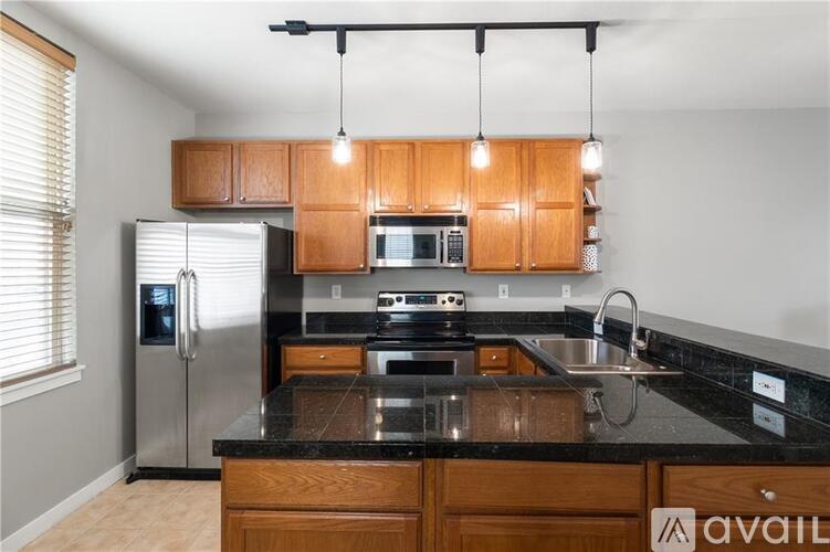 A kitchen with wooden cabinets and a black countertop.