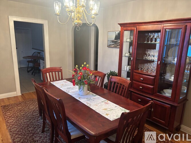 A dining room with a wooden table set for six.