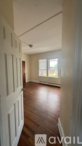 A hallway with a wooden floor and white walls.