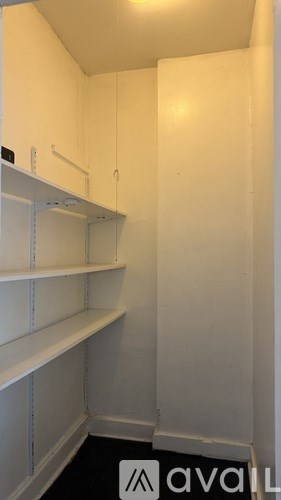 A white pantry with shelves and a sign that says "available".