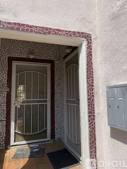 A doorway with a glass door and a red and white patterned wall.