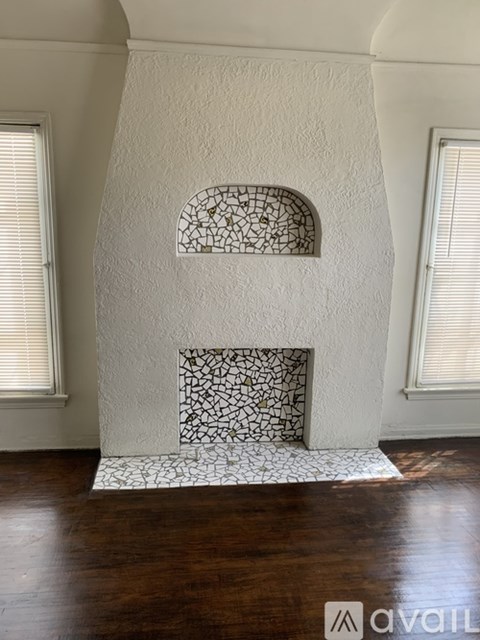 A fireplace with a white mantle and a black and white tile surround.