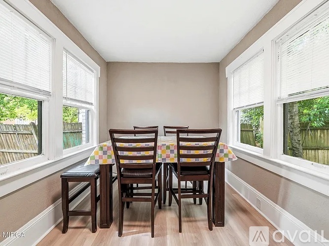 A dining room with a table and chairs.