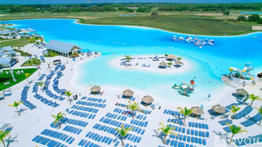 A large swimming pool with a water slide and sun loungers.