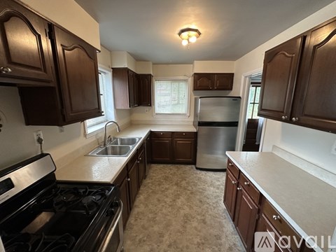 A kitchen with dark brown cabinets and a stove top oven.