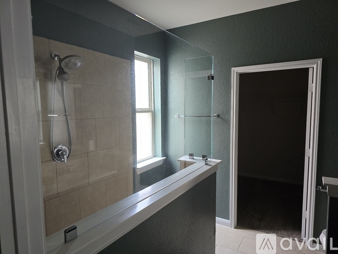 A bathroom with a glass shower door and a white bathtub.