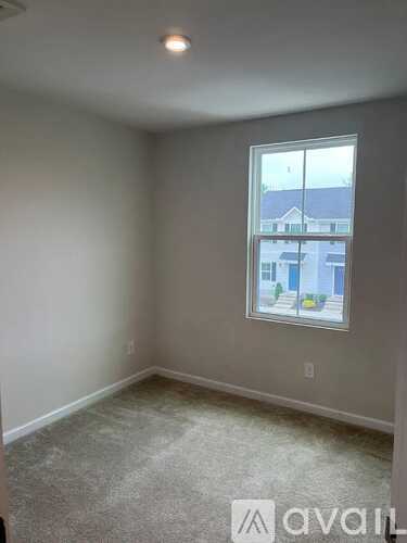 A room with a window showing a building outside.