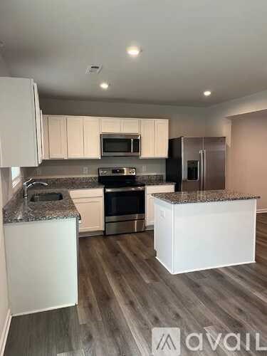 A kitchen with white cabinets and a granite countertop.