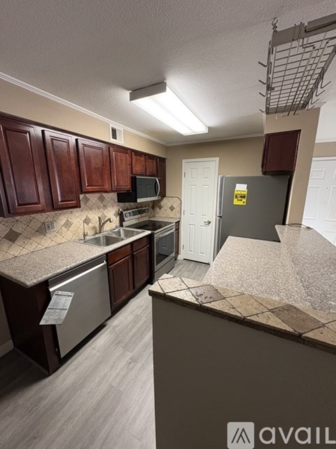 A kitchen with brown cabinets and a stainless steel dishwasher.