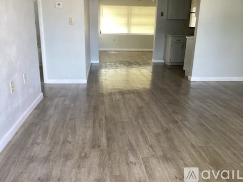 A room with wooden flooring and white walls.