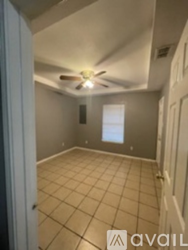 A room with a ceiling fan and tiled floor.