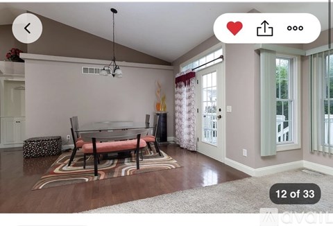 A living room with a dining table and chairs.