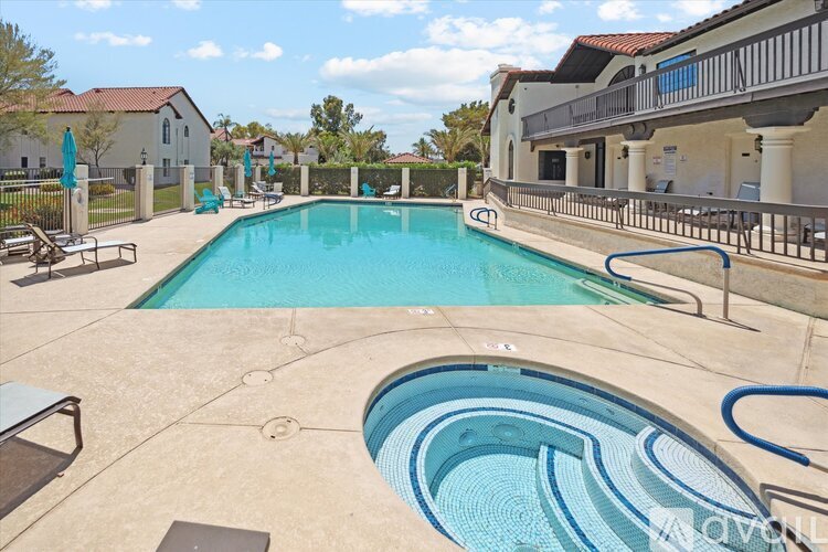 A large outdoor swimming pool with a hot tub in the middle.