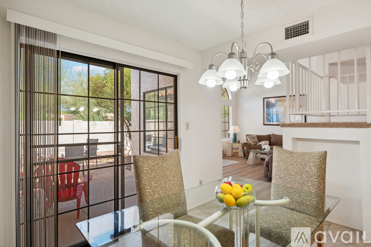 A dining room with a glass table and chairs.