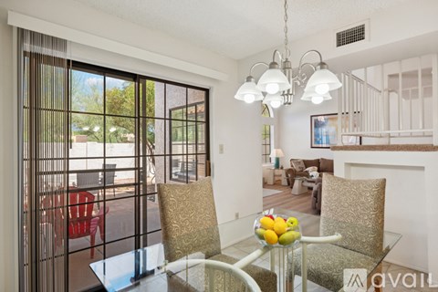 A dining room with a glass table and chairs.