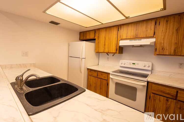 A kitchen with a sink, refrigerator, and stove.