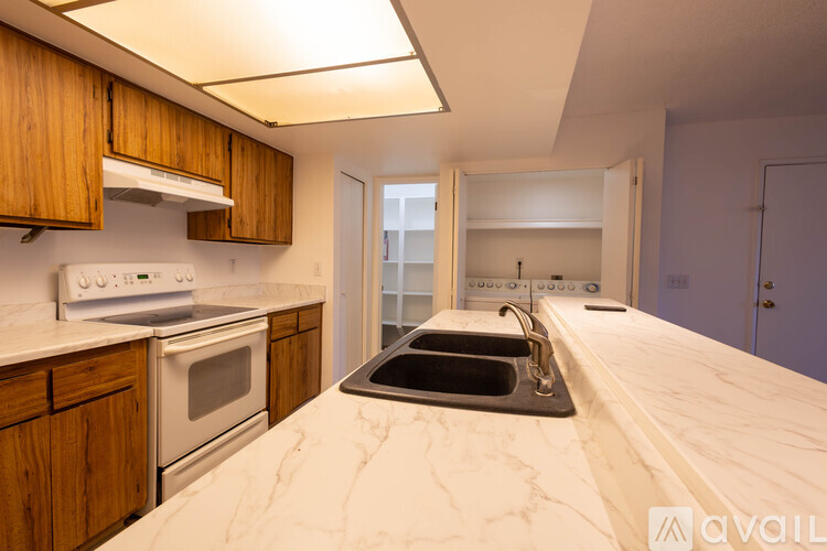 A kitchen with a white counter top and wooden cabinets.