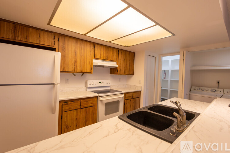A kitchen with wooden cabinets and a white fridge.