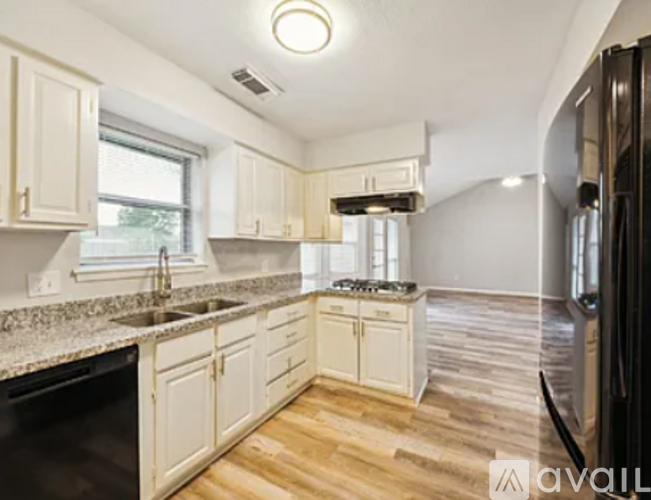 A kitchen with wooden floors and white cabinets.