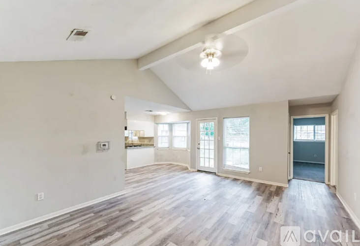 A spacious living room with wood flooring and a ceiling fan.