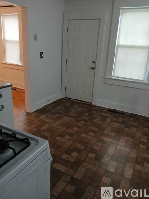 A kitchen with a tiled floor and a white door.