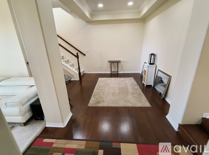 A living room with a white sofa and a wooden floor.