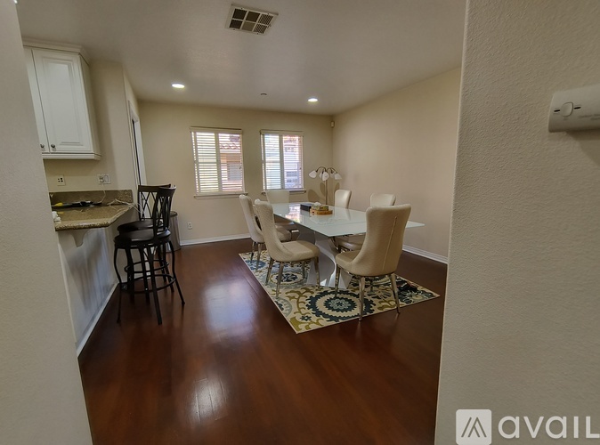 A kitchen with a dining table and chairs.