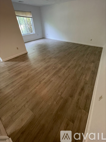 A room with wooden flooring and a window.