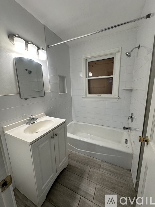 A bathroom with a white sink and a white bathtub.