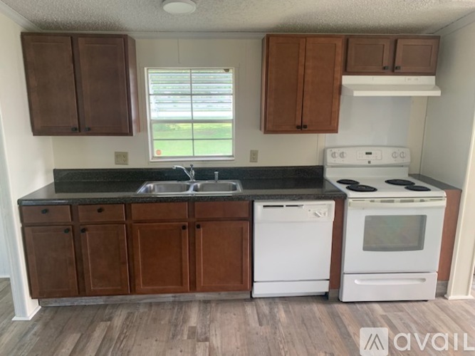 A kitchen with white appliances and brown cabinets.