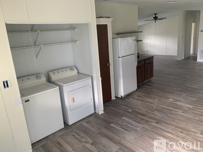A kitchen with a white refrigerator, a white dishwasher, and a white washing machine.