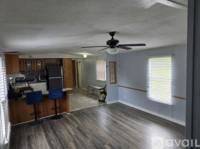 A room with a ceiling fan and wooden flooring.