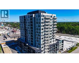 A tall residential building with a parking lot in front.
