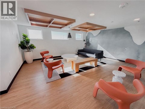 A living room with orange chairs and a black couch.