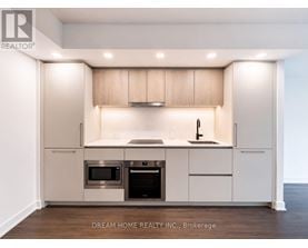 A modern kitchen with a sink, stove, and cabinets.