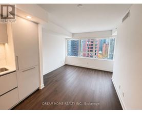 A room with wooden floors and white walls, with a window showing a city view.
