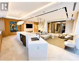 A modern kitchen with a white island and a painting on the wall.