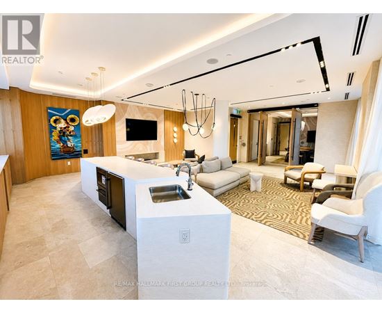 A modern kitchen with a white island and a painting on the wall.
