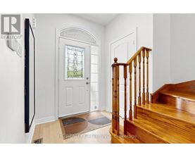 A wooden staircase with a white door and a window in the background.