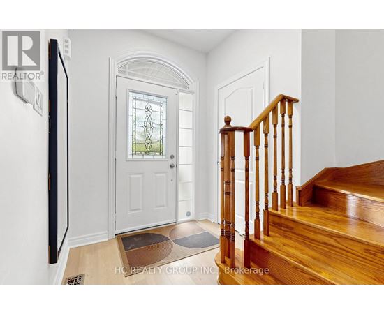 A wooden staircase with a white door and a window in the background.