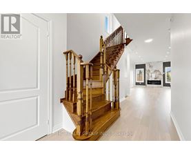 A wooden staircase in a house leads to the second floor.