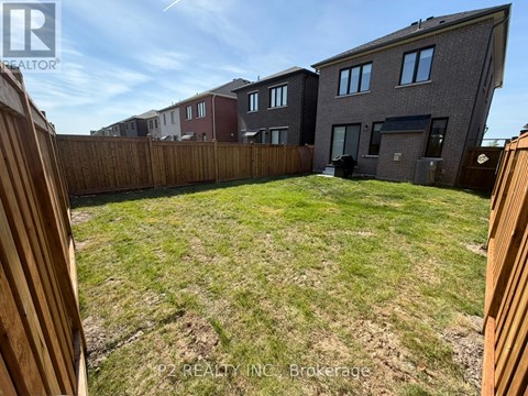 A backyard with a wooden fence and a grassy area.