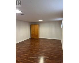 A room with wooden flooring and a wooden door.