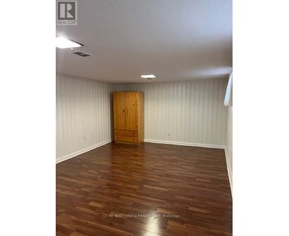 A room with wooden flooring and a wooden door.