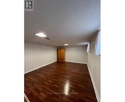 A room with wooden flooring and a wooden door.