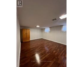 A room with wooden flooring and a wooden door.